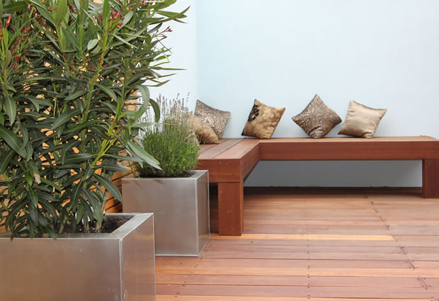 Outdoor SW12 Garden Design Balhamroom in Balham SW12 with an hardwood decking, feature rendered wall, contemporary planter, high bamboo, designed bespoke furnitures, garden lighting for a warm atmosphere