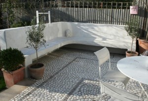 SE22 Garden Design East Dulwich in a mediterranean style, mosaic pebbles, pots, white rendered walls, in-built seating area, courtyard